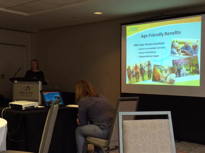 Presenter and the presentation screen that highlights age friendly benefits to healthy built environments