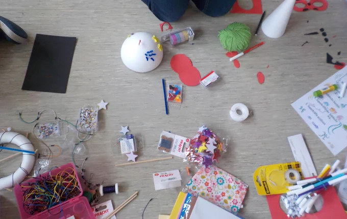 a variety of crafting materials with some assembled little objects  with bits and pieces sticking out of them.