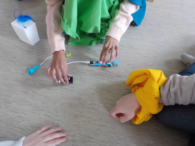 several different hands combining little bit technologies with crafting material.