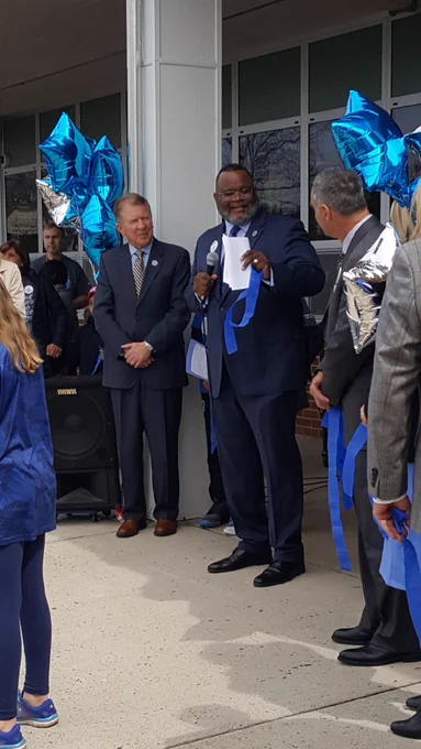 Dr. Repollet holding the cut ribbon to symbolize the beginning of the autism awareness walk