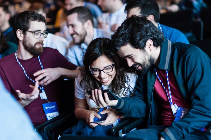 People smiling while interacting at typeof conf