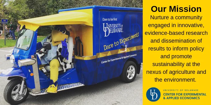 YouDee riding on the UD-CEAE tuktuk with text: "Our Mission: Nurture a community engaged in innovative, evidence based research and dissemination of results to inform policy and promote sustainability at the nexus of agriculture and the environment."
