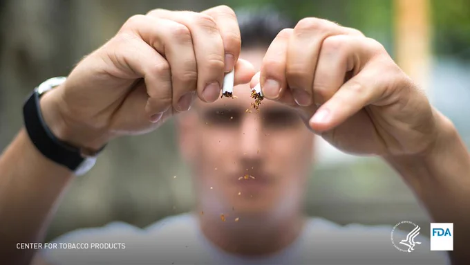 A man breaking a cigarette. 