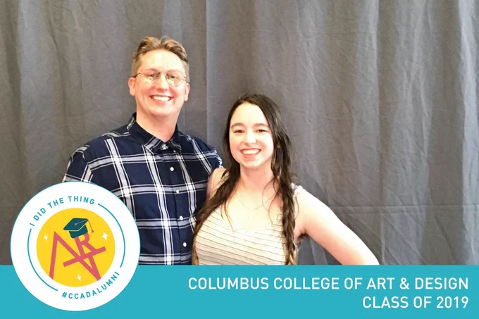 A man with glasses and blonde hair in a blue plaid shirt, a girl with long brown hair in braids   they are smiling and standing in front of a black background. The lower third reads "I did the thing. #ccadalumni. Columbus college of art and design class of 2019"