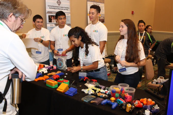 Students at ATIA 2019 Maker Day stand behind their table, which is covered with multicolored plastic tools 