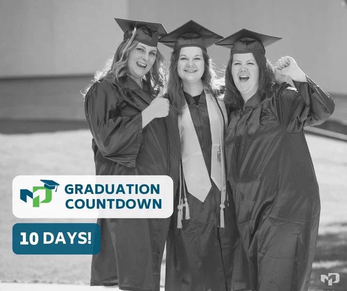 Three female students standing together in their graduation caps and gowns.
