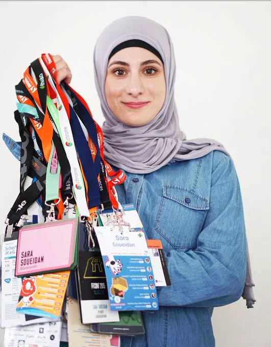 Me holding my conference badges