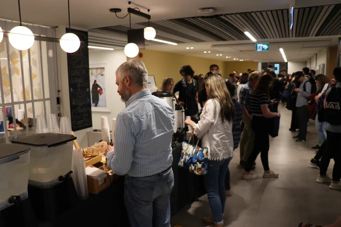 Welcome Day participants grab coffee at a refreshments table.