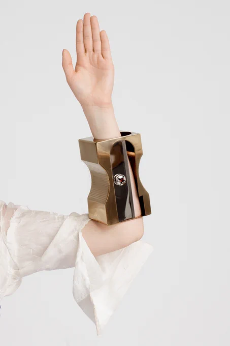 A person wearing a large pencil sharpener shaped bracelet