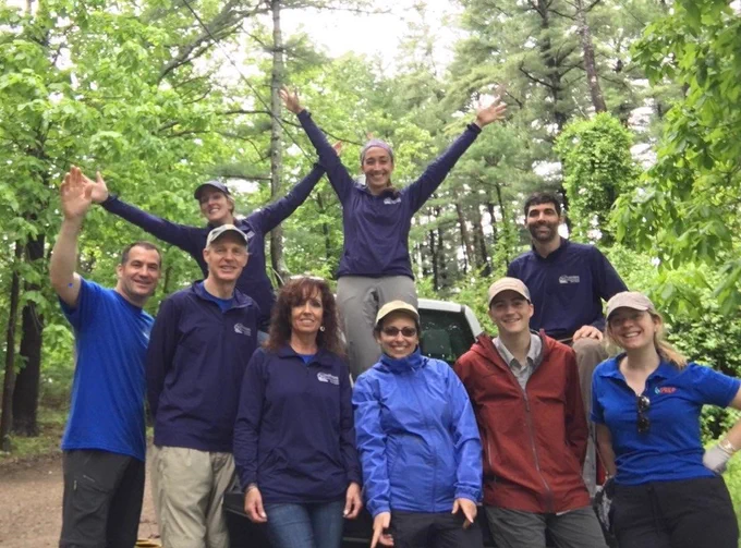image of nine people smiling in front of truck