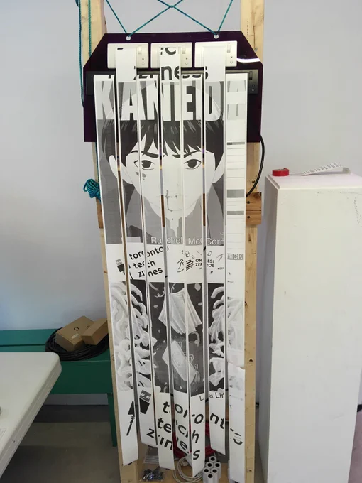 a tall continuous poster, made of seven receipt printers printing side by side