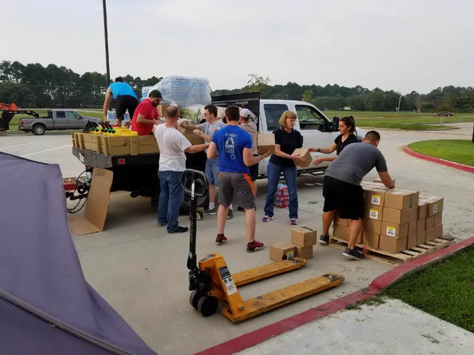 Volunteers load boxes into the back of a white pickup truck.