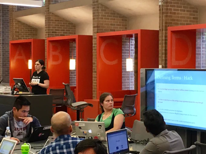 Sarah in a Black Lives Matter shirt presenting to participants with laptops