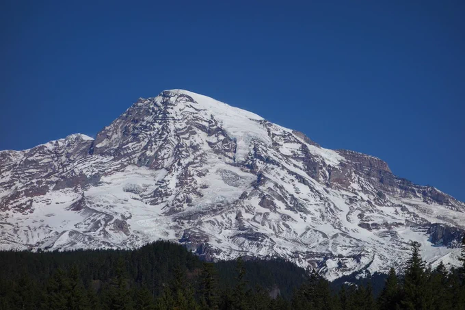 Glaciated mountain peak against a clear blue sky.