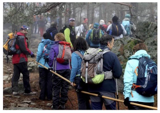 Miembros del grupo de montaña de la ONCE ascendiendo hacia la cumbre de Cabeza Lijar en la Sierra de Guadarrama