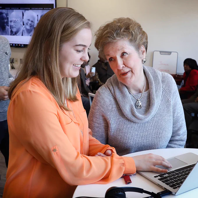 Carolyn Raihala ’18 (l) and partner Ida Williams review stories and photographs that illustrate the psychology of memory.