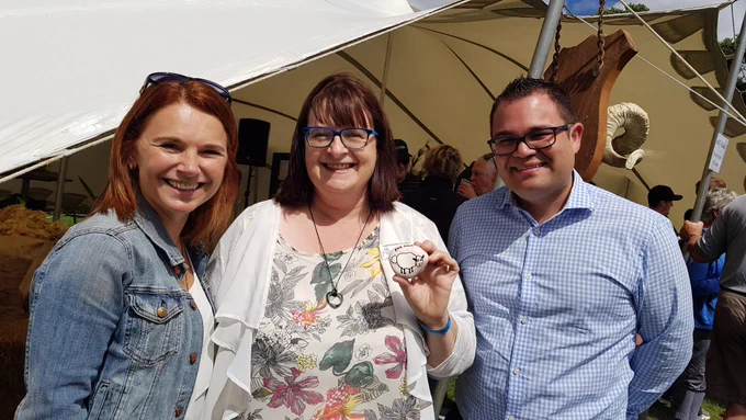 Rachel Bowen and Tangi Utikere with me holding a painted rock with a sheep on it.