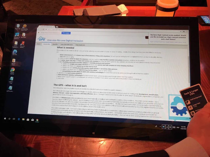 Windows tablet with an NFC enabled individual card (Dark & Larger 175%) resting on the sensor, gear icon displayed, signifying the card is being successfully "read" with a browser page opened to content.