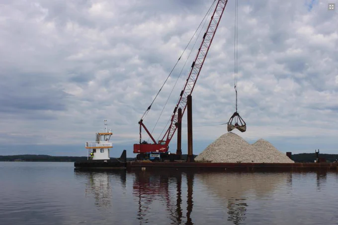Barge cranes crushed shells from a floating platform into the waters of Great Bat New Hampshire