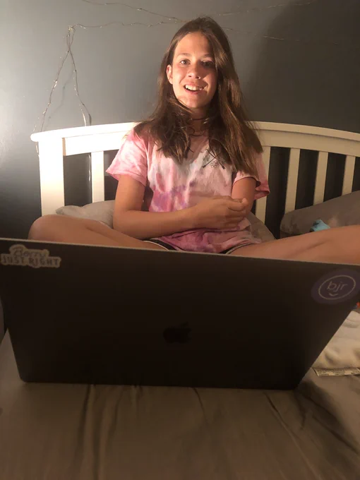 Jordan sits crisscross behind an open laptop.