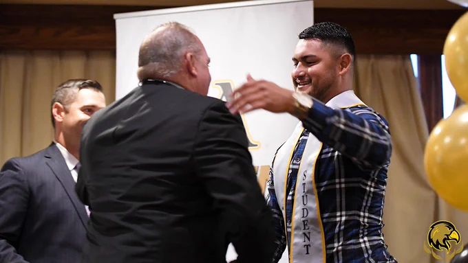 George and coach Vince hug.