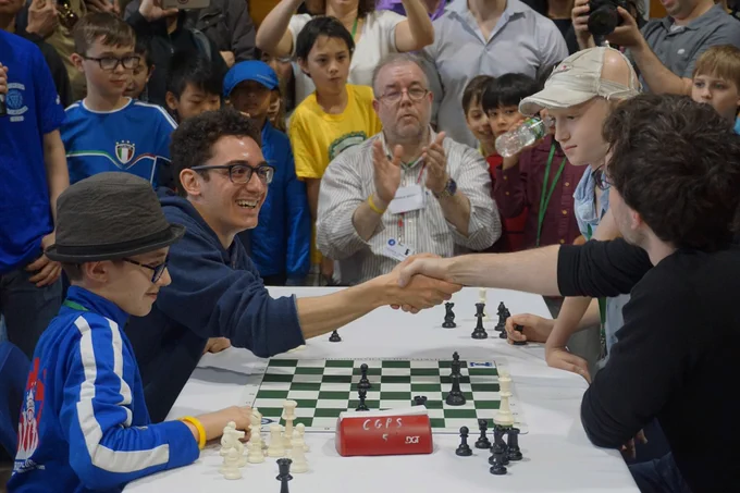 World Championship challenger Fabiano Caruana shakes Grandmaster Robert Hess's hand at charity chess.