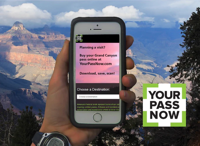 A hand holds a smart phone out, displaying a message that reads "Buy your grand canyon pass online at YourPassNow.com. Download, save, scan!" Grand Canyon landscape in background. In corner, a logo for Your Pass Now