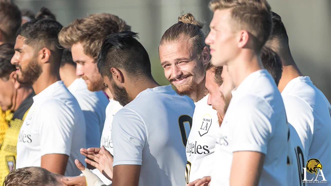 Soccer player Steven Eberle smiles toward the camera with sun in his eyes.