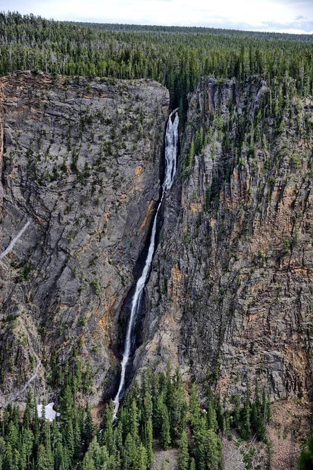 A thin waterfall cascades down a canyon wall.