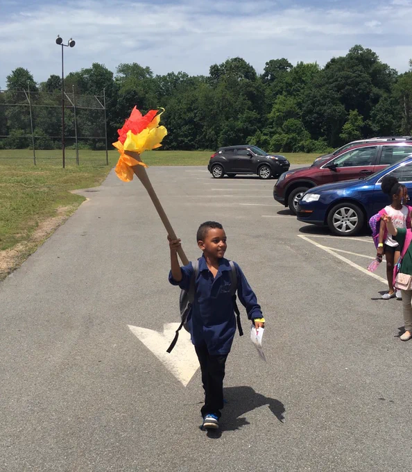 Student Carrying a Paper Torch