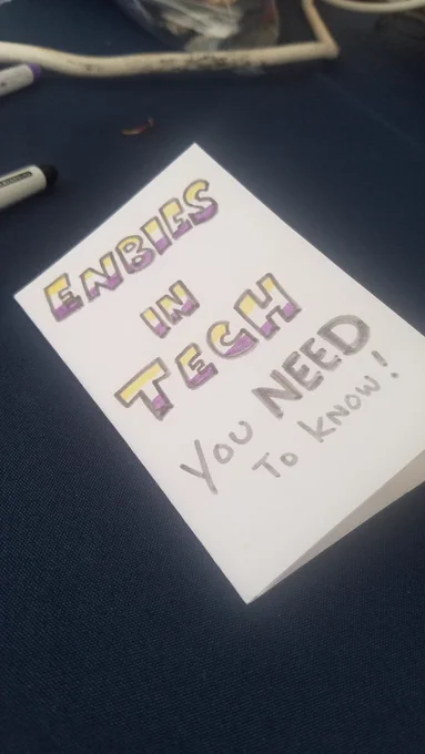 a small zine with the words "Enbies in tech you need to know!" with yellow and purple lines filled into the letters