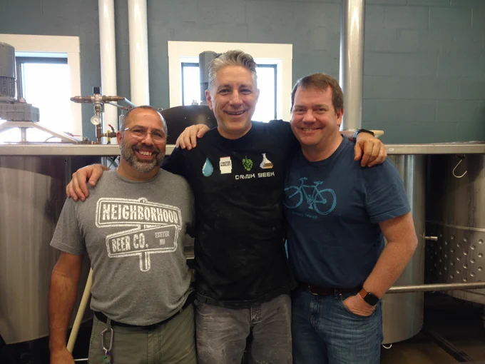 Crew at Neighborhood Beer Co. pose in front of their kegs.