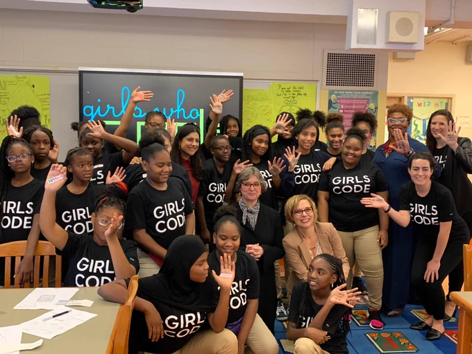 A group of girls in GIRLS CODE tee shirts raise their hands - on their hands is the word SISTERHOOD. Also in the picture is the first lady of Pennsylvania, Frances Wolf, as well as Corinne Roller, Director of Advocacy at Girls Who Code, and Chrissy Ziccarelli, Director of Education at Girls Who Code.