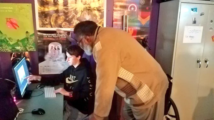 Board Member Ned James speaking with student about animation