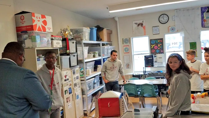Students explaining robotics project to Dr. Repollet