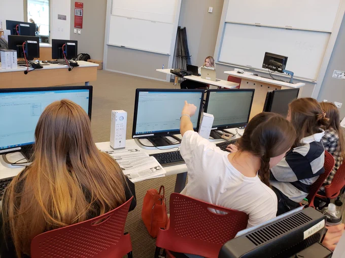 Girls at computers writing SQL in APEX at U Girls Code