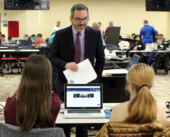 Matt Stem speaks to two students participating in the Cyber Robotics Coding Competition
