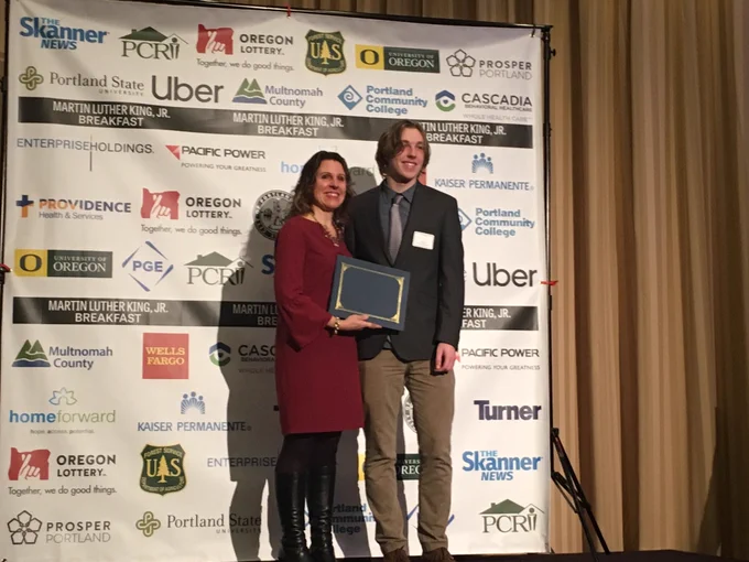 Chair Deborah Kafoury awards Multnomah County’s first Skanner MLK Breakfast scholarship award to Central Catholic High School Student Kai Mills.