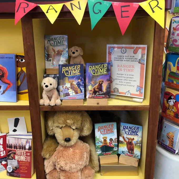 A display of Kate Messner’s Ranger in Time series, complete with banner and stuffed doggos.