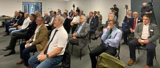 Members of the business summit, seated watching a presentation 