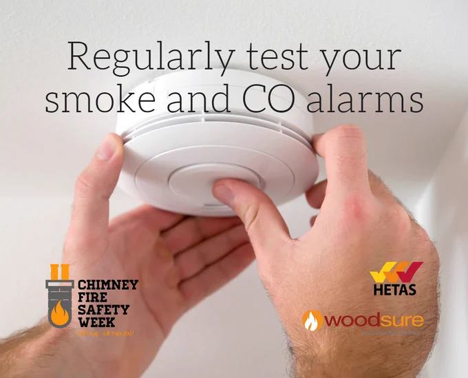 Regularly test your smoke and carbon monoxide alarms - an image of a pair of hands pressing the button to test an alarm