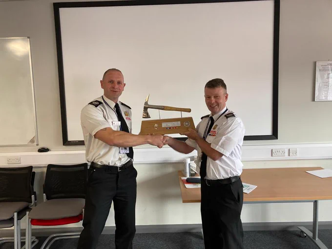 Fire Officers presenting axe to retiring officer.