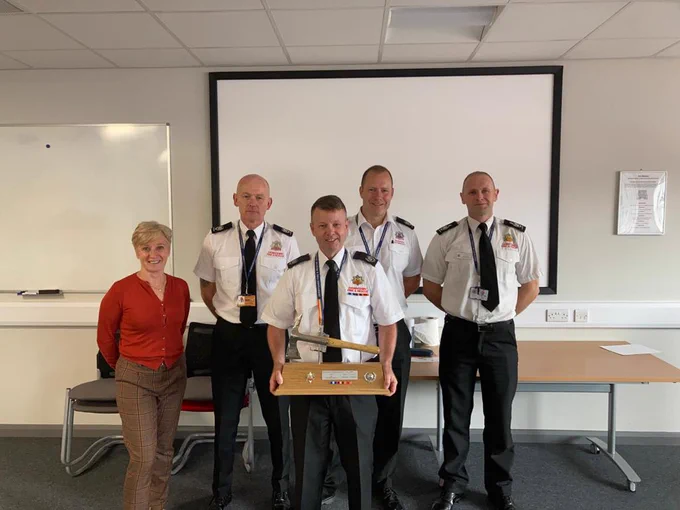 Fire Officers presenting axe to retiring officer.