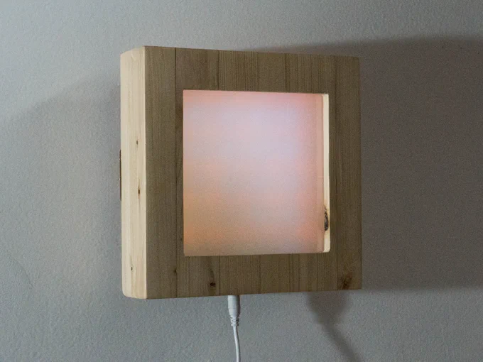 a wood box with a white screen shows a color fade 