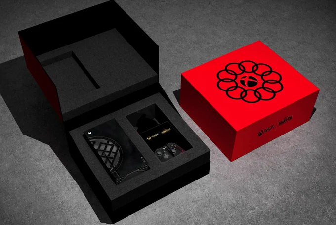 A red box with the Xbox logo surrounded by 10 interlocked rings sits next to an open black box. A Shang-Chi-themed Xbox Series X and controller are inside.