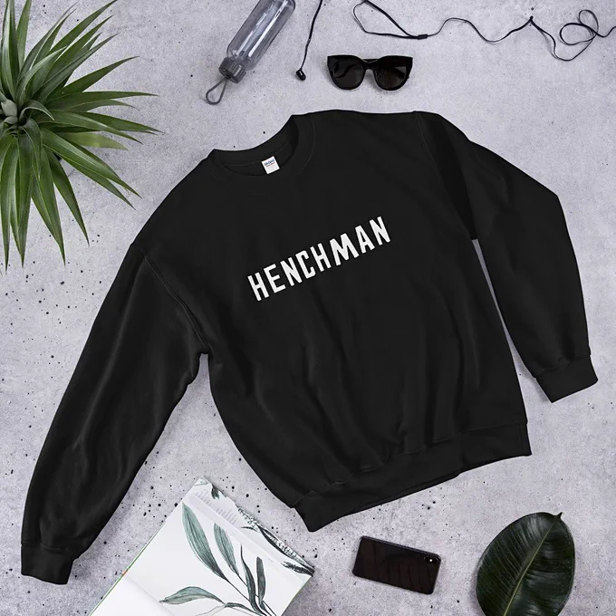 A black sweater featuring the word HENCHMAN in blocky off white letters.