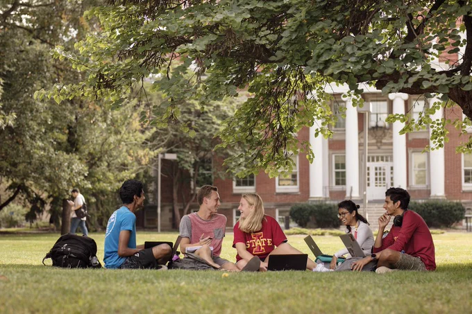 Students sitting outside in front of building