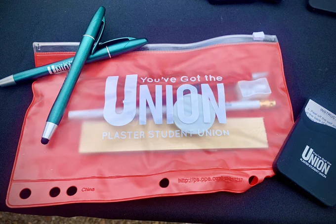 Photo of supplies at table including pens, a bag, etc…