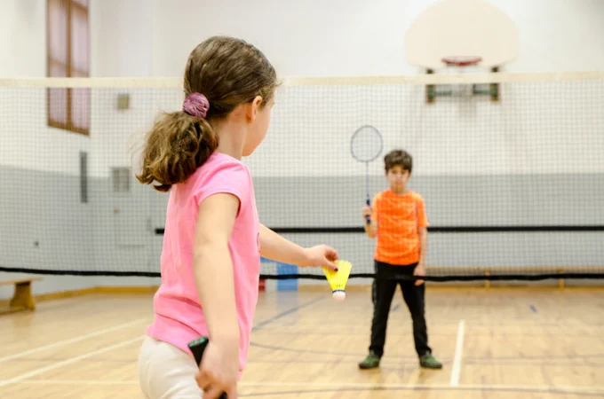 Children playing badminton in gym