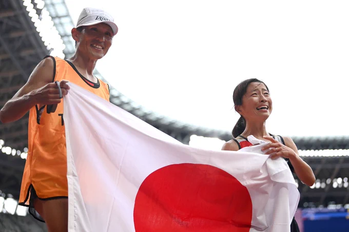 Misato Michishita of Team Japan celebrates with her guide after winning the gold medal during the women's Marathon.